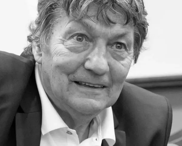 Portret Ryszarda Jedlińskiego w garniturze i białej koszuli. Jego twarz jest lekko uśmiechnięta, a oczy patrzą wprost na widza.