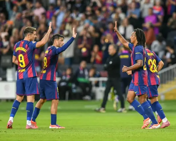 Piłkarze FC Barcelona, w tym Lewandowski, świętują zwycięstwo. Duma i radość na twarzach, to jest **vive Barcelona**!