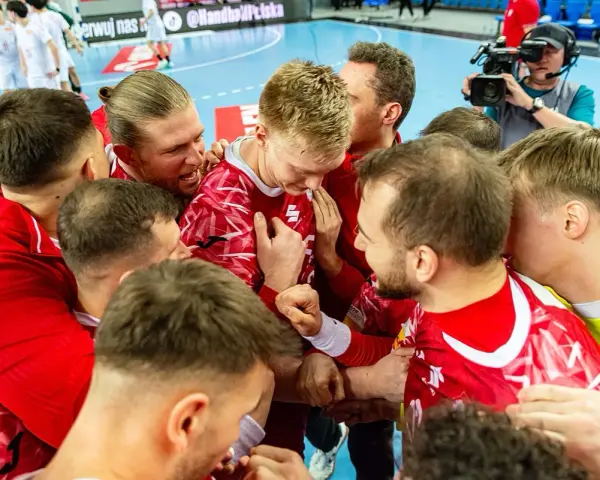 Piłkarze ręczni w czerwonych strojach świętują zwycięstwo. Emocje po meczu, a gdzieś w tle czeka mistrzostwa świata w piłce ręcznej terminarz.