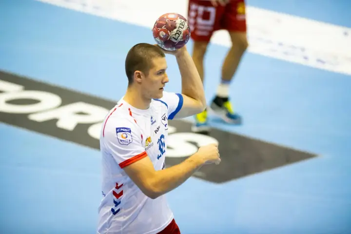 Wiktor Tomczak, zawodnik piłki ręcznej, przygotowuje się do rzutu.