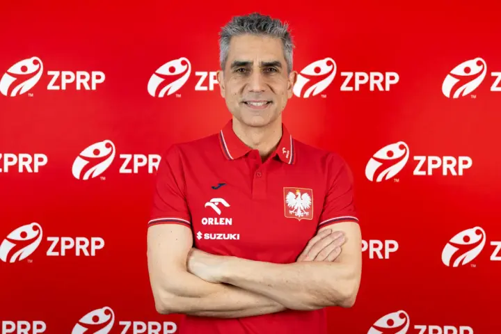 Trenerzy reprezentacji Polski w piłce ręcznej, w tym nowy selekcjoner, pozują na tle czerwonej ściany z logo ZPRP.