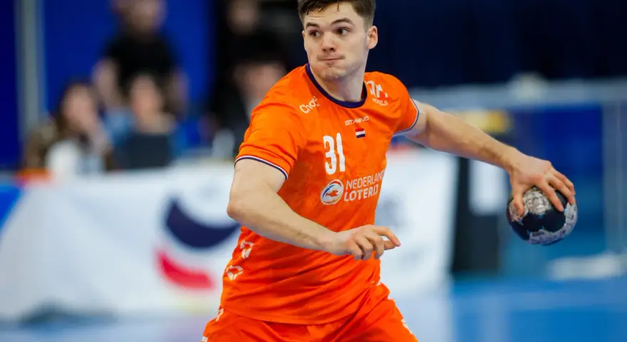 Kay Smits w pomarańczowej koszulce z numerem 31, gotowy do rzutu piłką ręczną.