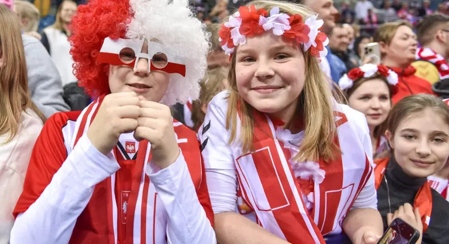 Dzieci kibicują w barwach narodowych podczas meczu pierwszej ligi piłki ręcznej.