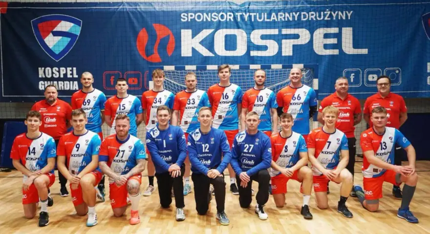 Drużyna Gwardia Koszalin piłka ręczna pozuje do zdjęcia. Zawodnicy w strojach sportowych z numerami na koszulkach.
