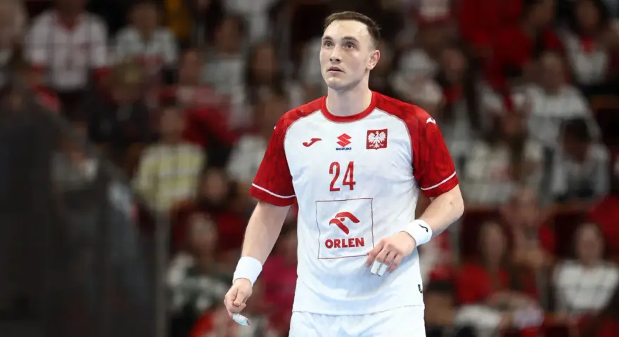 Wiktor Jankowski, numer 24, w białej koszulce z czerwonymi rękawami, z orłem na piersi, na tle trybun.