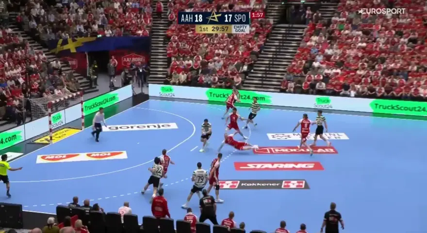 Piłkarze FC Barcelona Handball w akcji, walczą o każdą bramkę. Dynamiczna gra na parkiecie, tłumy kibiców na trybunach.