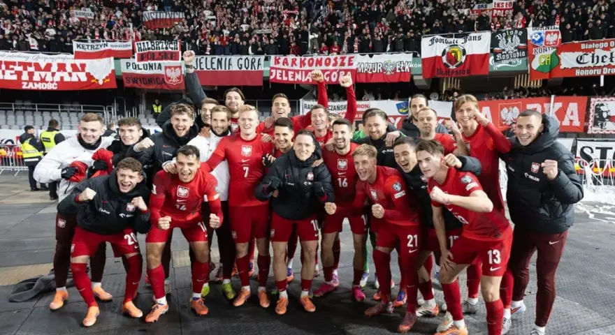 Radosna me grupa polska w czerwonych strojach świętuje z kibicami.