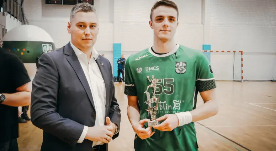 Andrzej Widomski z pucharem w ręku, obok młody sportowiec w zielonej koszulce.