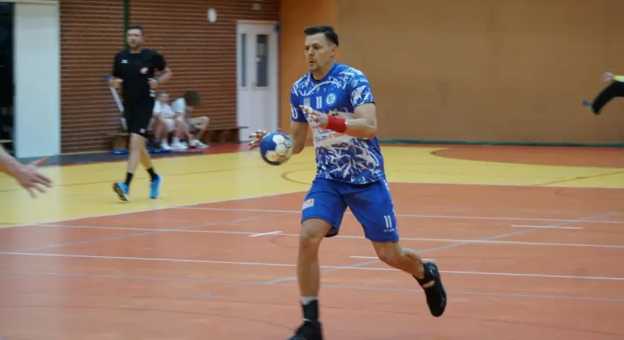 Kamil Krieger w akcji na boisku do piłki ręcznej, z piłką w dłoni, gotowy do rzutu.