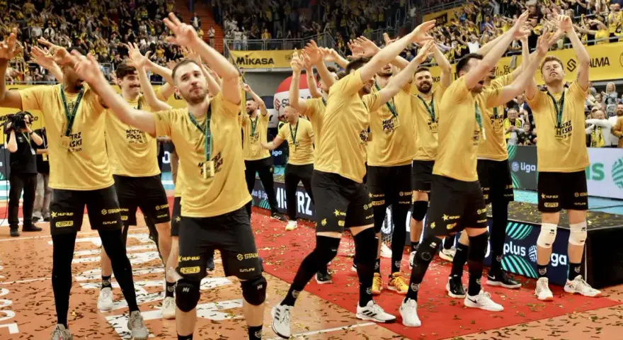 Drużyna MKS Lublin świętuje zwycięstwo na boisku, otoczona konfetti i wiwatującymi kibicami.