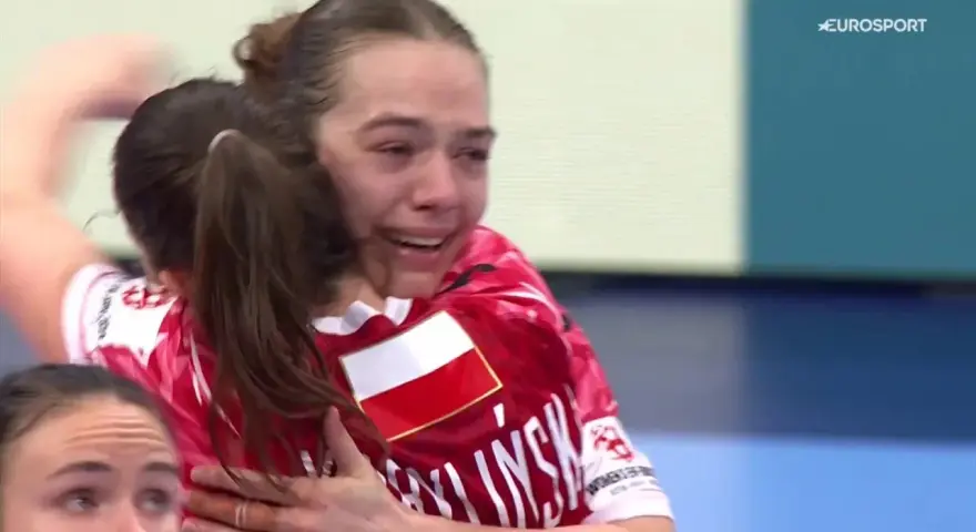 Emocjonalne objęcie po zwycięstwie. Barbara Jeż ze łzami radości na twarzy, w koszulce z polską flagą.