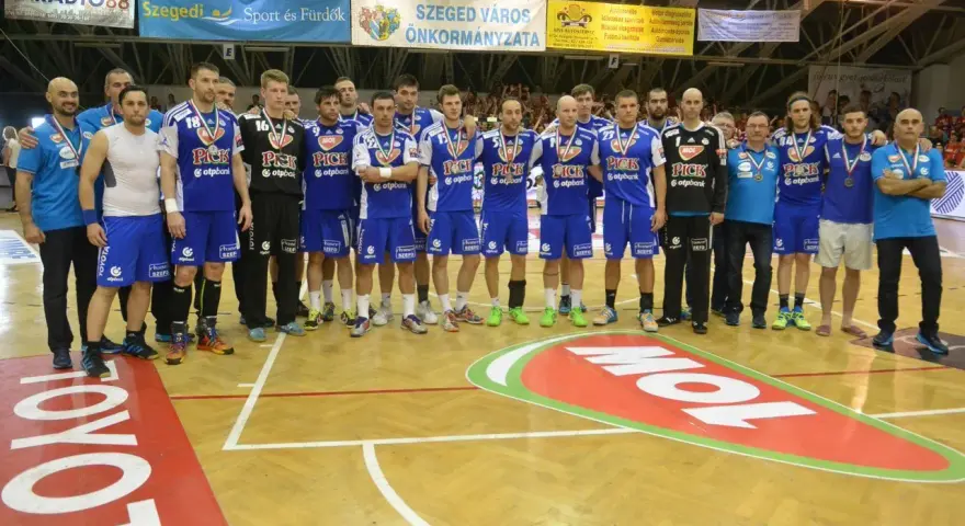 Drużyna piłkarzy ręcznych PICK Szeged w niebieskich strojach pozuje do zdjęcia po meczu.