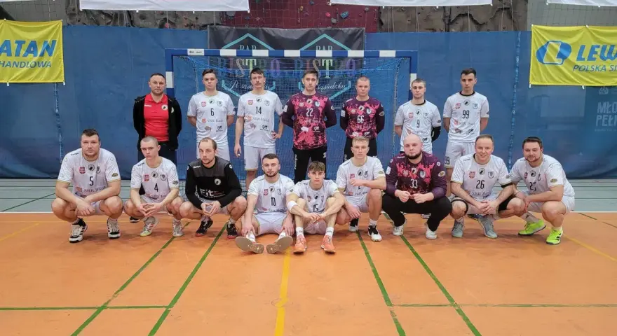 Drużyna piłkarzy ręcznych, w tym Wojciech Stec, pozuje do zdjęcia w hali sportowej.