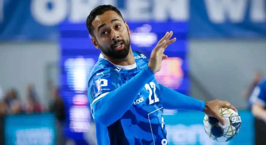 Gracz gog handball w niebieskiej koszulce z numerem 22, gotowy do rzutu.