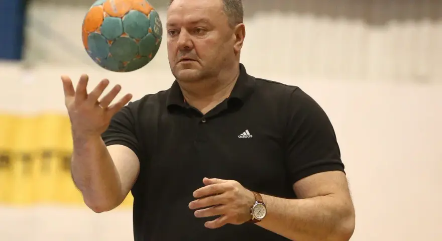 Rafał Malinowski, trener, rzuca piłką do ręcznej.