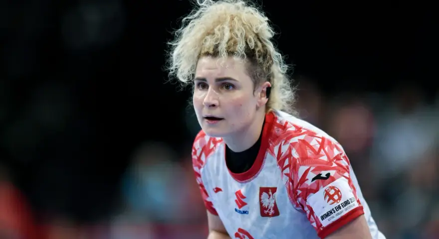 Sylwia Matuszczyk, zawodniczka w białej koszulce z czerwonymi wzorami, skupiona na boisku.