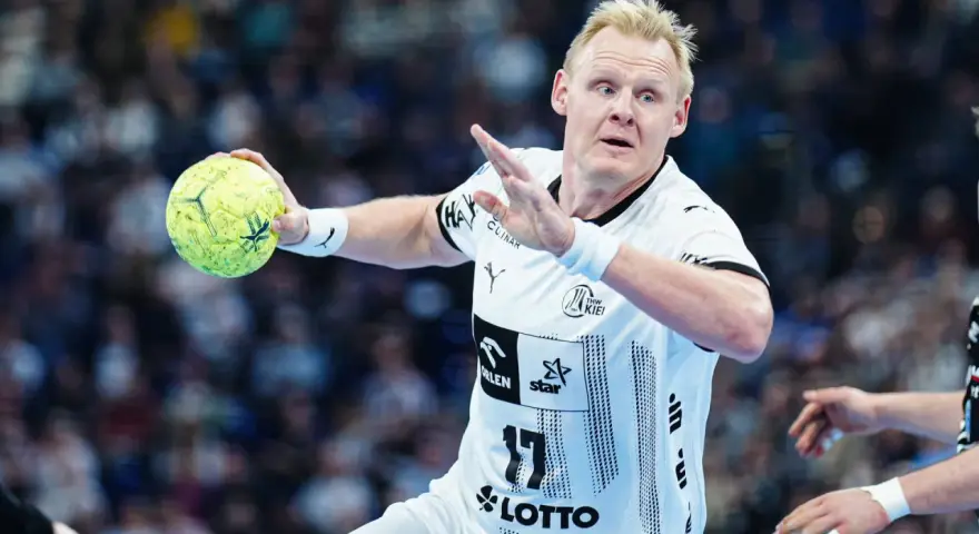 Patrick Wiencek w akcji, z piłką w ręku, gotowy do rzutu.
