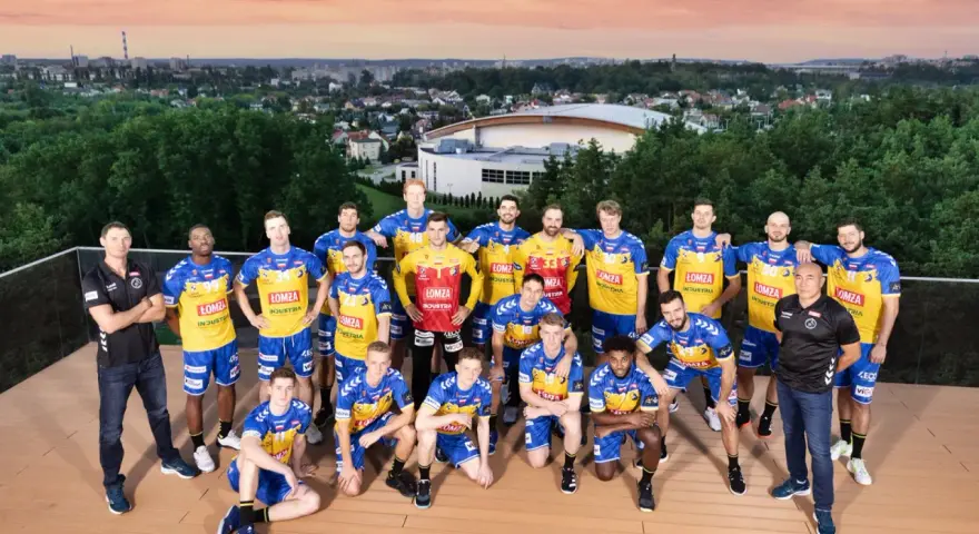 Drużyna piłkarzy ręcznych Vive Kielce pozuje do zdjęcia na tle panoramy miasta.
