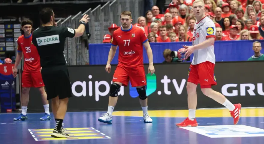Daniel Reznicky w czerwonej koszulce z numerem 77 na boisku do piłki ręcznej.