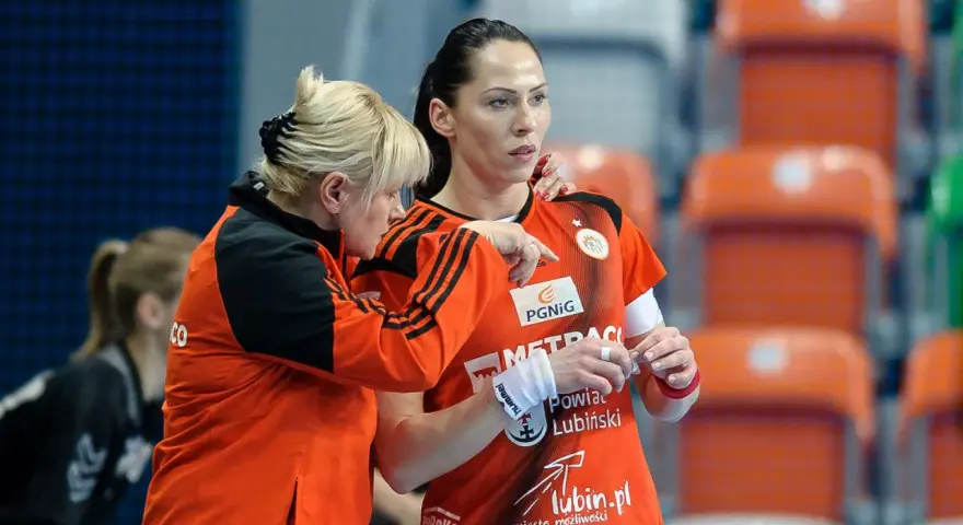 Wiktoria Jaroniewska w akcji podczas meczu piłki ręcznej. Trenerka udziela wskazówek zawodniczce.