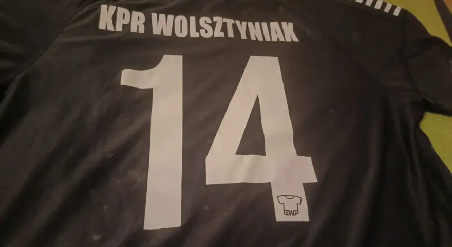 Czarna koszulka z napisem "KPR Wolsztyniak" i numerem 14.