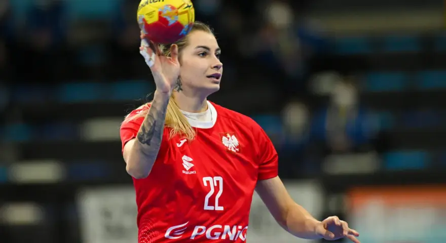 Aleksandra Rosiak w akcji, rzuca piłkę ręczną. Zawodniczka w czerwonej koszulce z numerem 22.