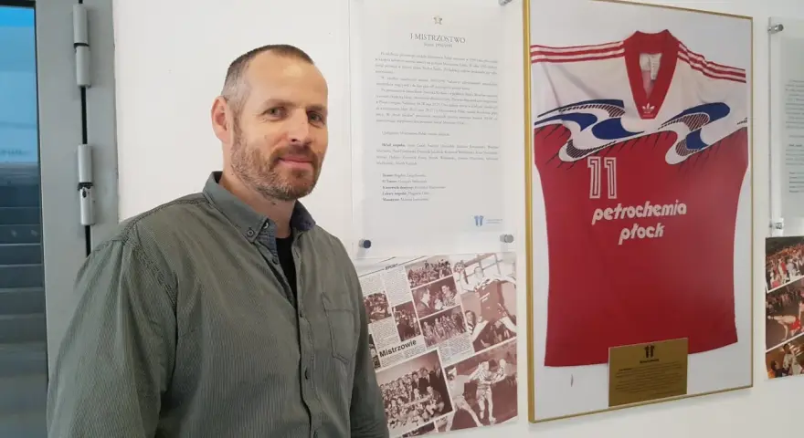 Michał Dębski na tle koszulki "Petrochemia Płock" z numerem 11, upamiętniającej mistrzostwo Polski w sezonie 1994/1995.