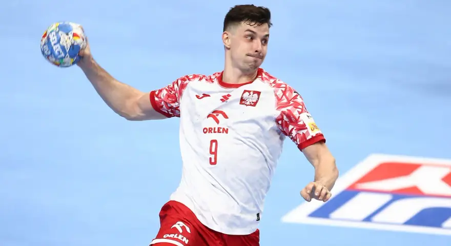 Szymon Sićko w akcji, rzuca piłkę ręczną.