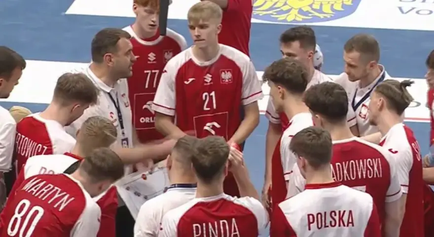 Drużyna PGNiG piłka ręczna w czerwonych strojach słucha trenera.