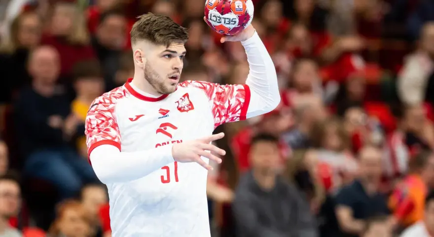 Szymon Działakiewicz w akcji, gotowy do rzutu piłką ręczną.