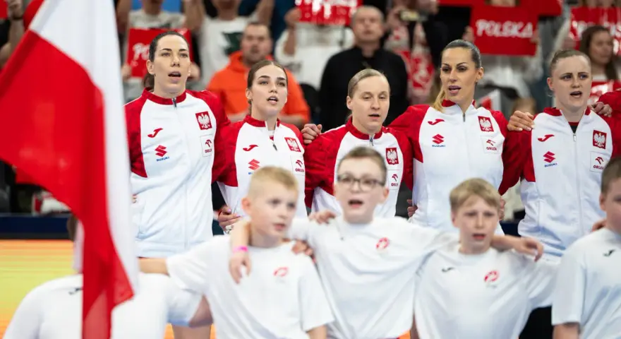 Drużyna Polski podczas mistrzostw Europy w piłce ręcznej kobiet. Kibice z transparentami "Polska" dopingują zawodniczki.