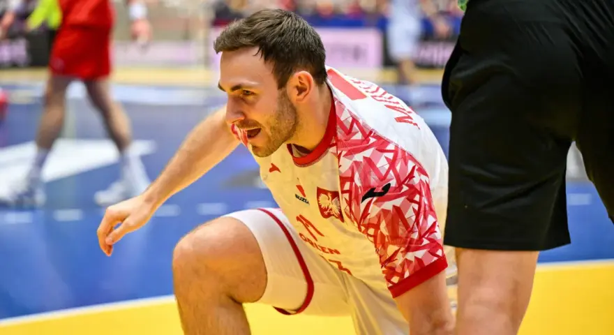 Arkadiusz Moryto w białej koszulce z czerwonymi wzorami, w akcji na boisku.