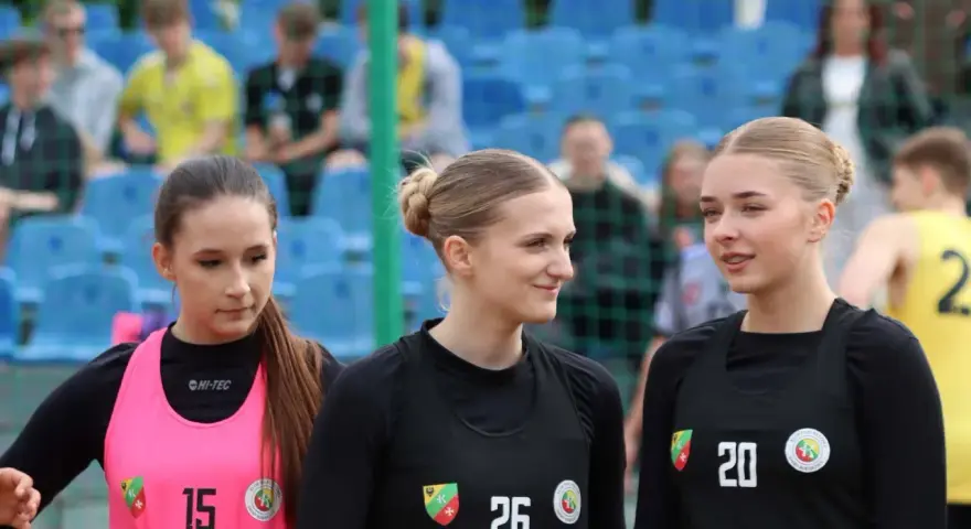 Trzy zawodniczki KPR Kobierzyce przed meczem. Dziewczyny w sportowych strojach, z numerami na koszulkach, gotowe do gry.