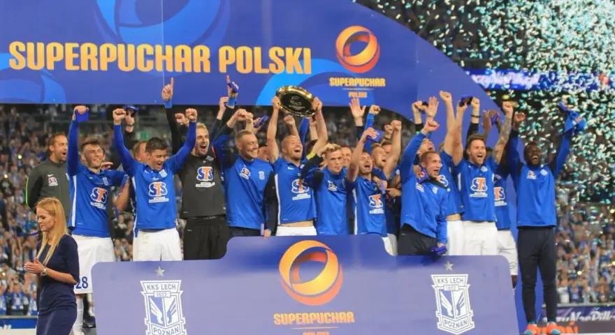 Drużyna w niebieskich strojach świętuje zdobycie Superpucharu Polski, unosząc trofeum i ciesząc się z wygranej wśród konfetti.