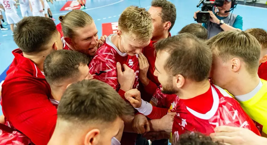Piłkarze ręczni w czerwonych strojach świętują zwycięstwo. Emocje po meczu, a gdzieś w tle czeka mistrzostwa świata w piłce ręcznej terminarz.