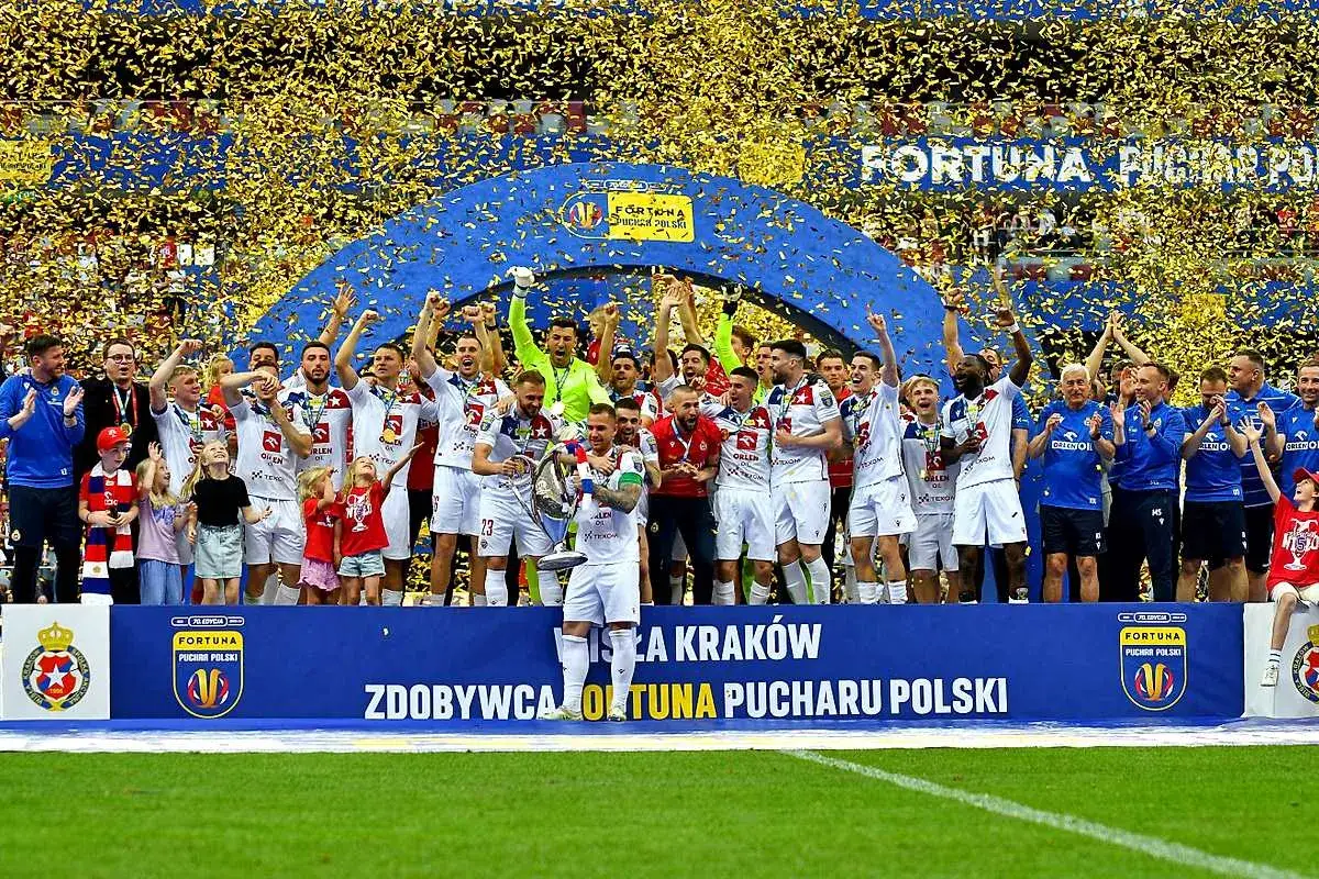 Piłkarze świętują zwycięstwo w półfinałach Pucharu Polski, obsypani złotym konfetti.