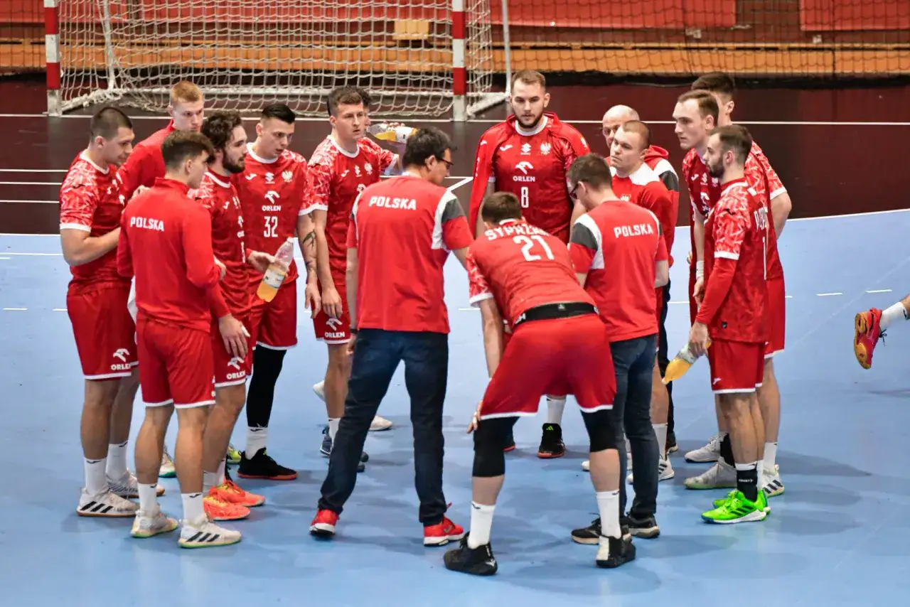 Drużyna piłki ręcznej Polska w czerwonych strojach omawia taktykę. Czekamy na kolejny mecz zgodnie z terminarzem.
