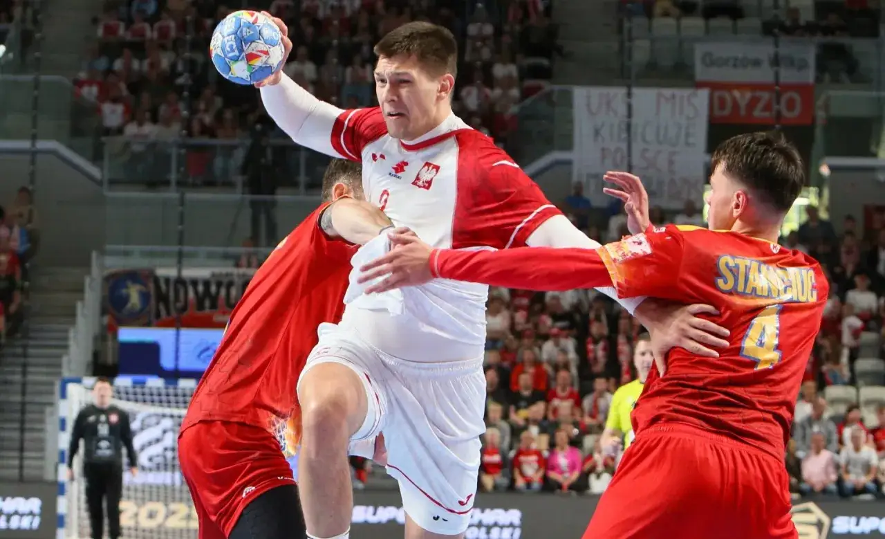 Damian Borkowski w akcji, rzuca piłkę do bramki przeciwnika, otoczony przez obrońców.