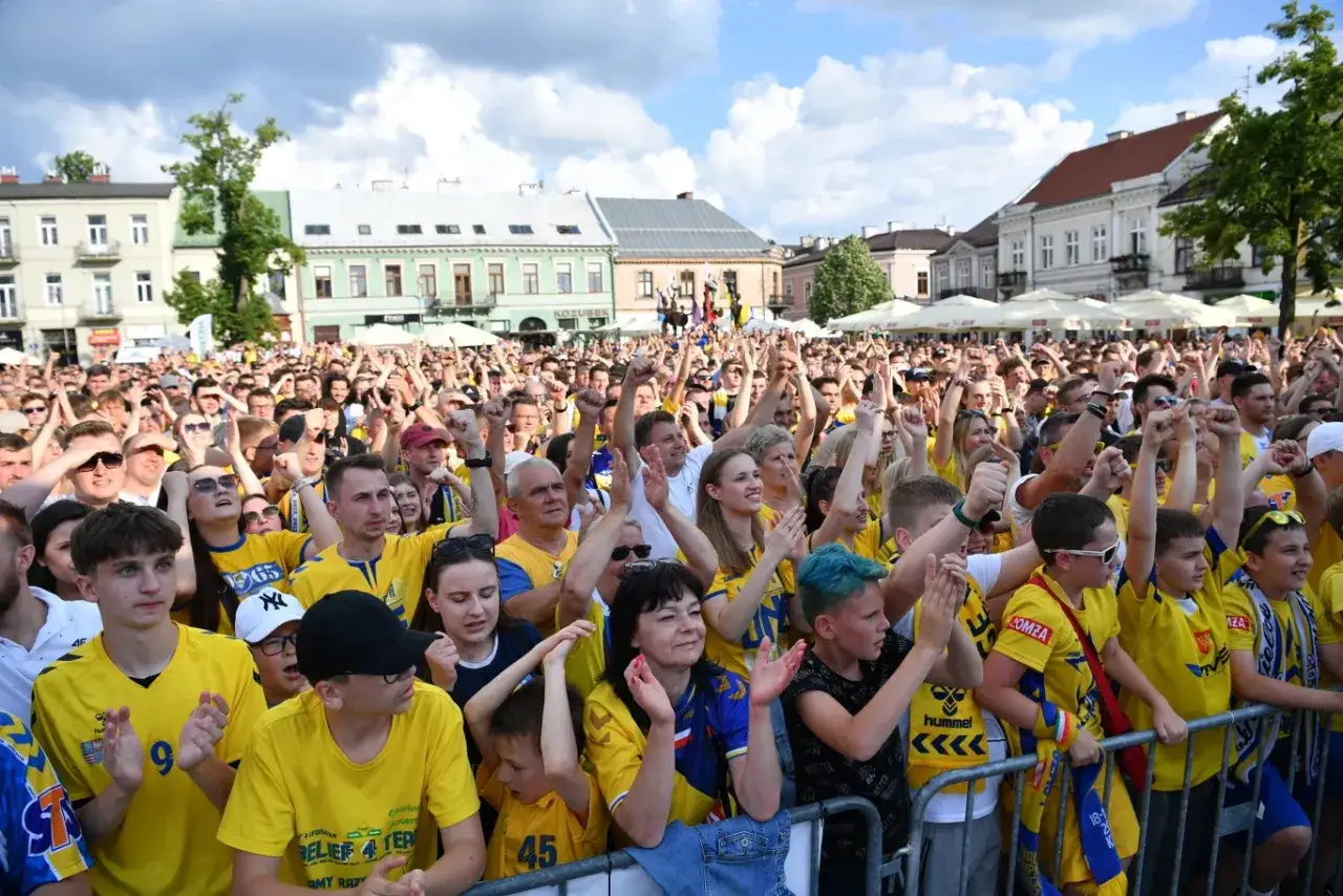 Tłum kibiców w żółtych koszulkach świętuje na zewnątrz, wspierając swoją drużynę w lidze europy piłka ręczna.