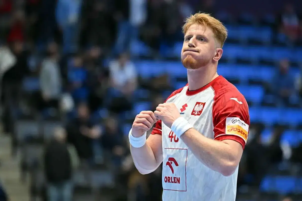 Tomasz Gębala, szczypiornista w biało-czerwonej koszulce z orłem, z zaciętą miną i zaciśniętymi pięściami.