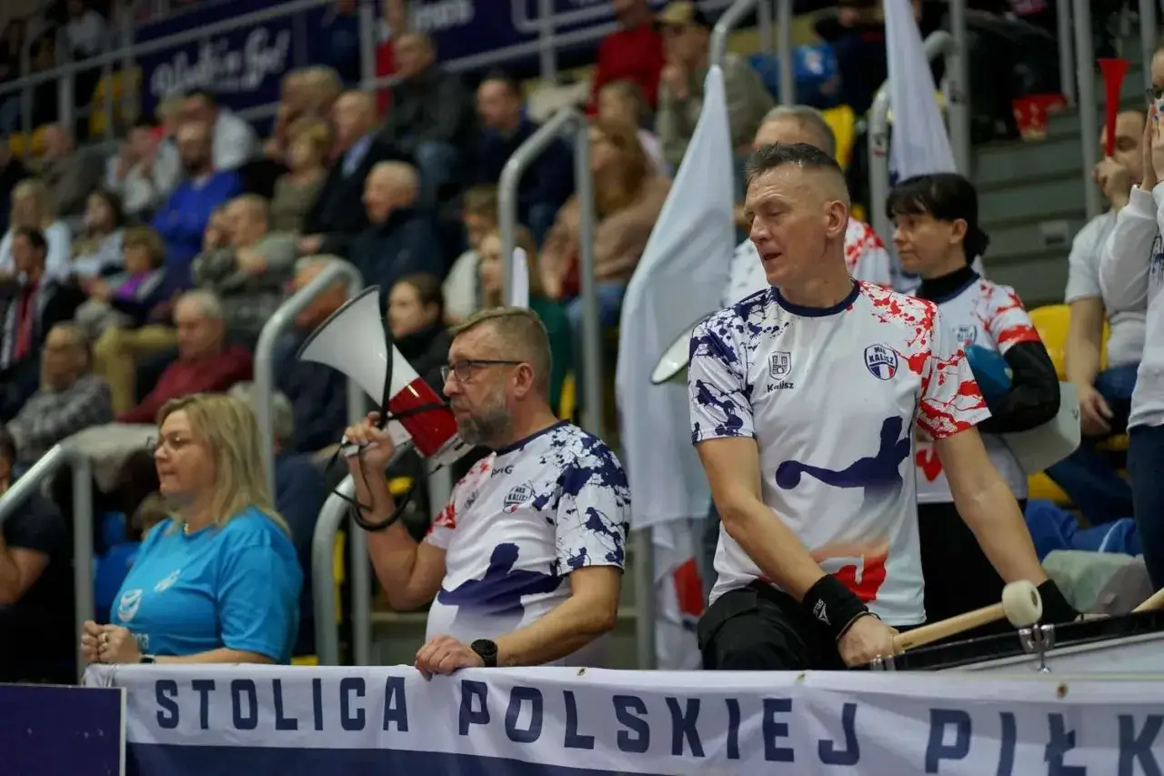 Chrobry Głogów: kibice zagrzewają do walki. Mężczyzna z megafonem i bębniarz dopingują drużynę podczas emocjonujących rozgrywek.
