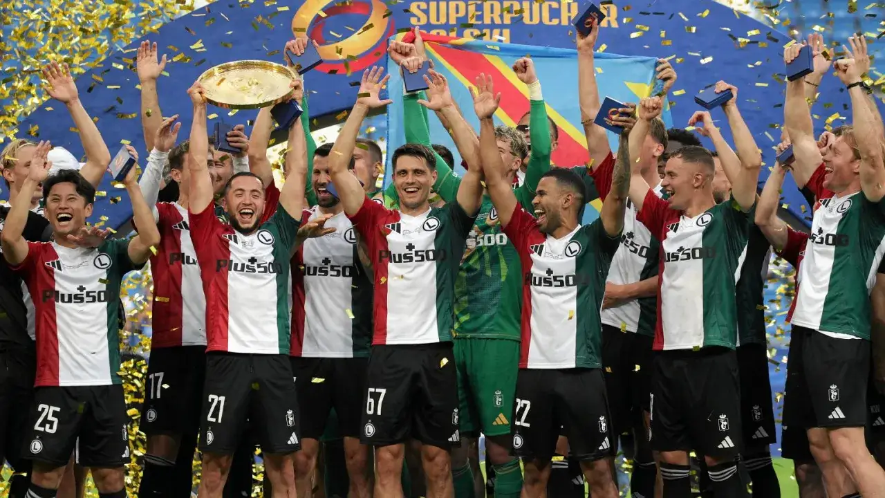 Piłkarze świętują zdobycie Superpucharu Polski, unosząc trofeum i rzucając konfetti.