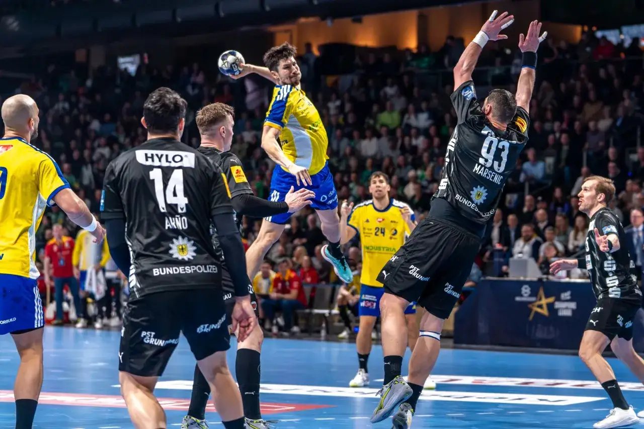 Piłka ręczna w akcji! Zawodnik w ż&oacute;łtej koszulce skacze do rzutu, a obrońcy z Kielc w czarnych strojach pr&oacute;bują go zatrzymać. Emocje w Lidze Mistrz&oacute;w!
