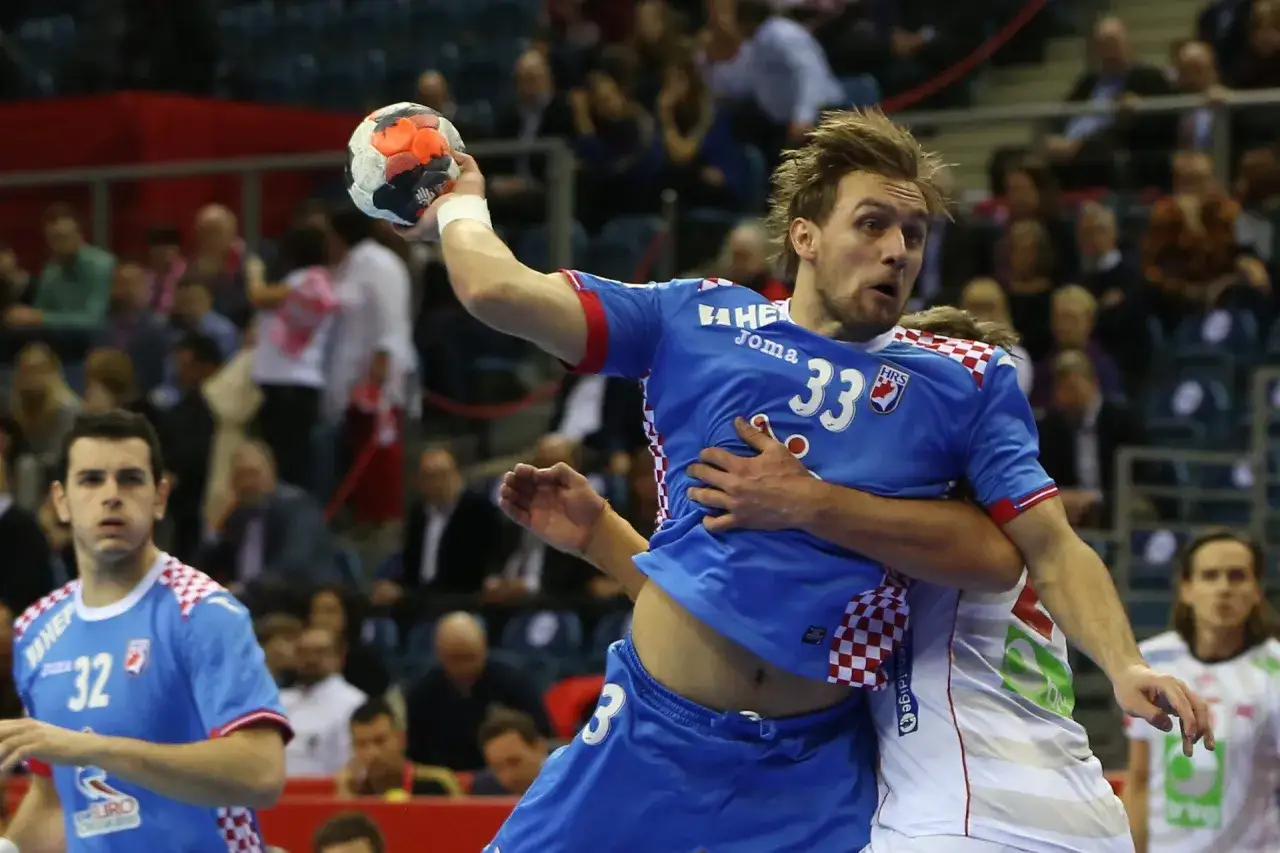 Luka Cindrić w akcji, rzuca piłkę do bramki przeciwnika.