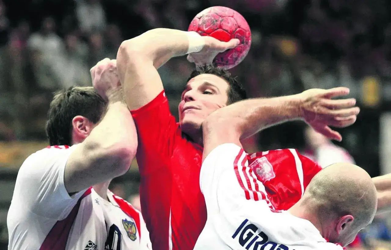 Tomasz Zaręba w akcji, walczy o piłkę w meczu piłki ręcznej.