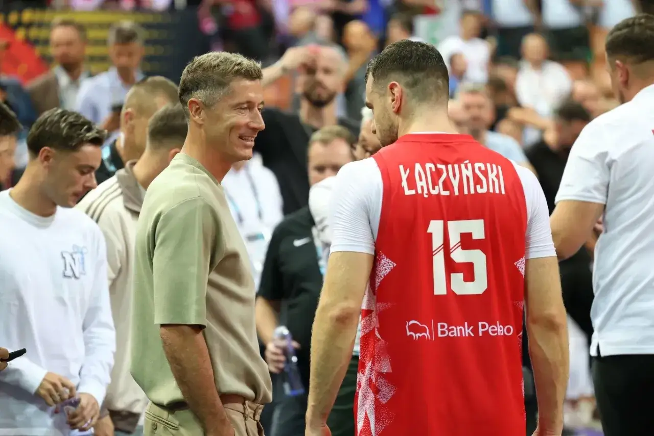 Kamil Lewandowski w rozmowie z zawodnikiem w czerwonej koszulce z numerem 15.