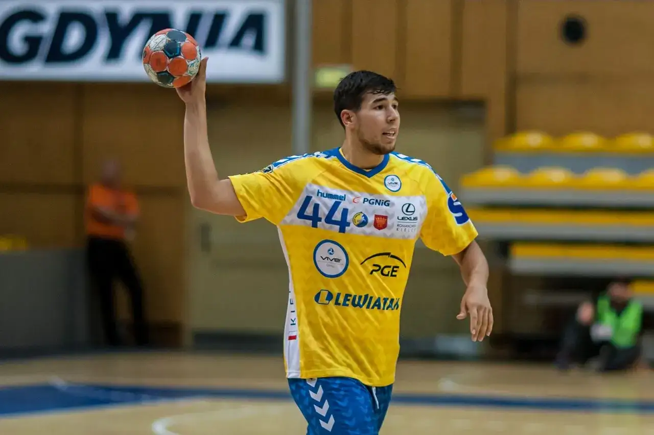 Daniel Dujshebaev w żółtej koszulce z numerem 44, gotowy do rzutu piłką ręczną.