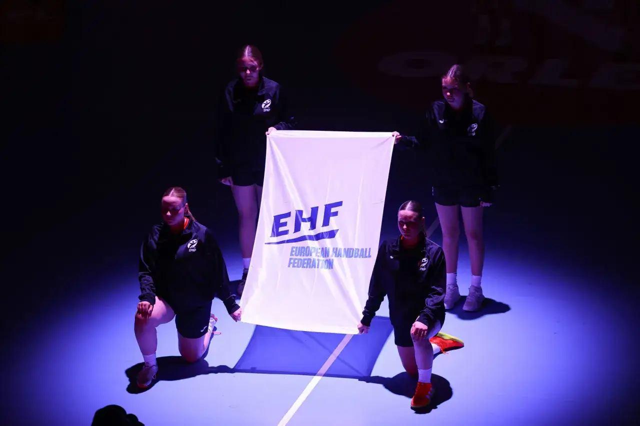 Cztery zawodniczki prezentują flagę EHF podczas mistrzostw europy w piłce ręcznej kobiet.