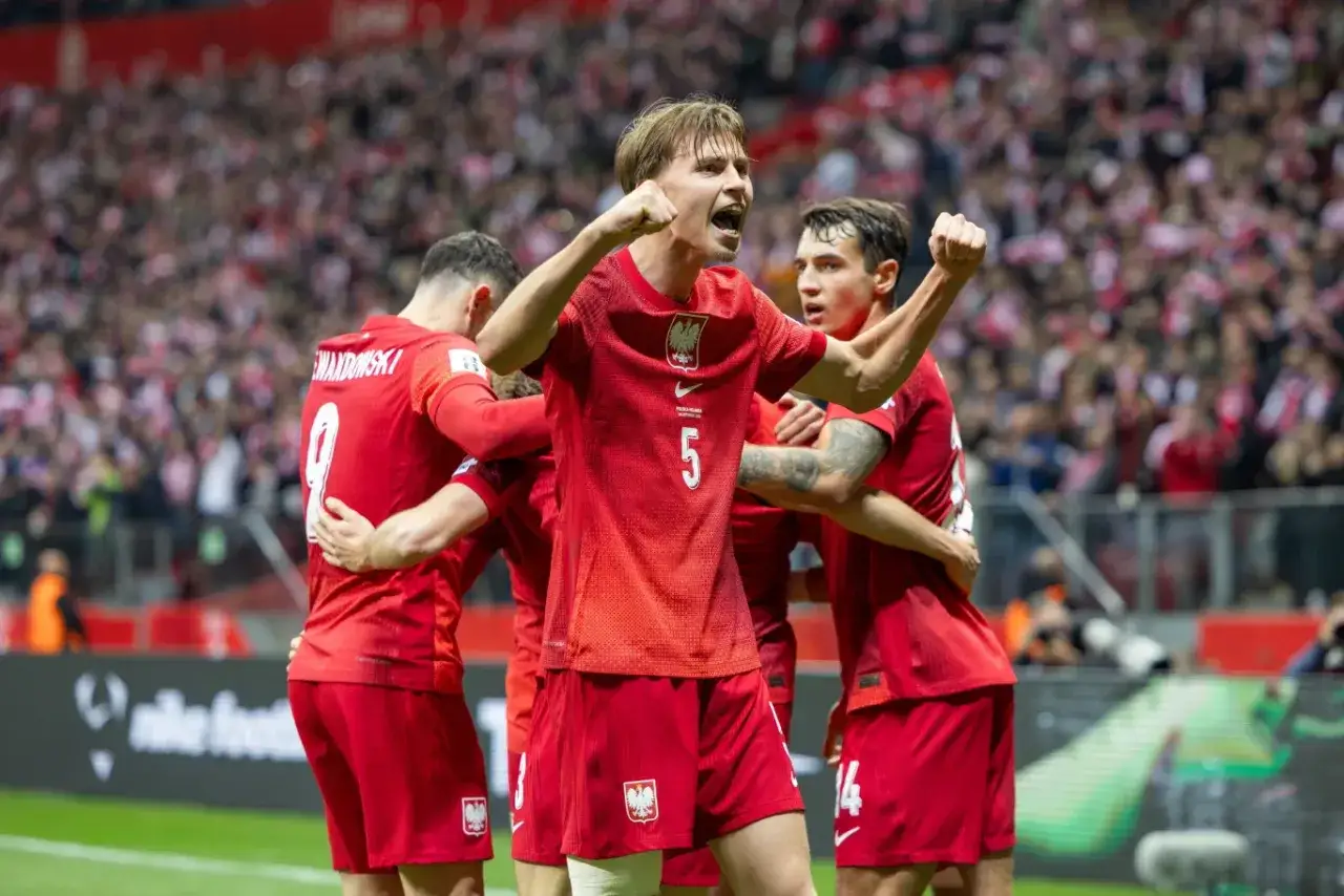Piłkarze w czerwonych strojach świętują bramkę. To nasza grupa polska, radość na trybunach!