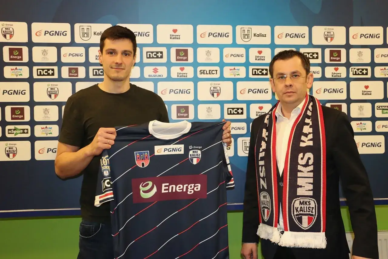 Maciej Pilitowski z koszulką MKS Kalisz, obok mężczyzna w szaliku klubu.